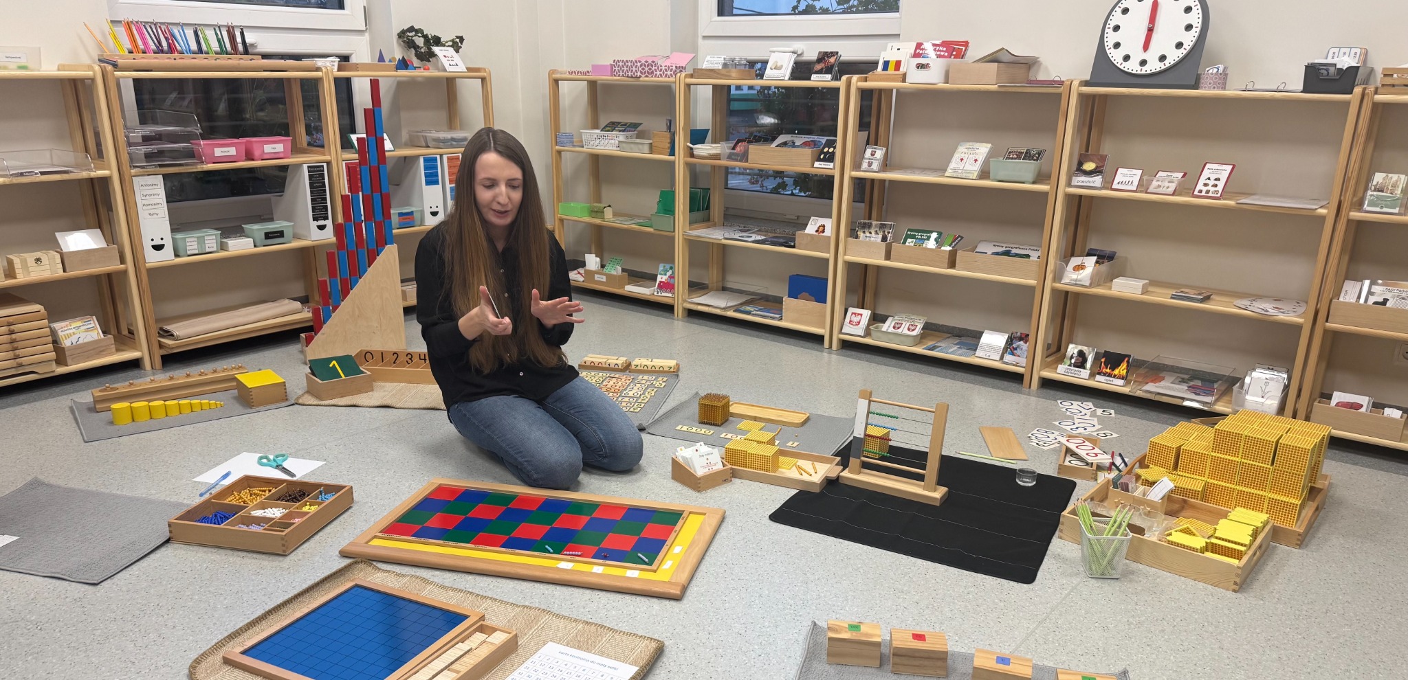 Ewa Reichel w sali Montessori z materiałami matematycznymi
